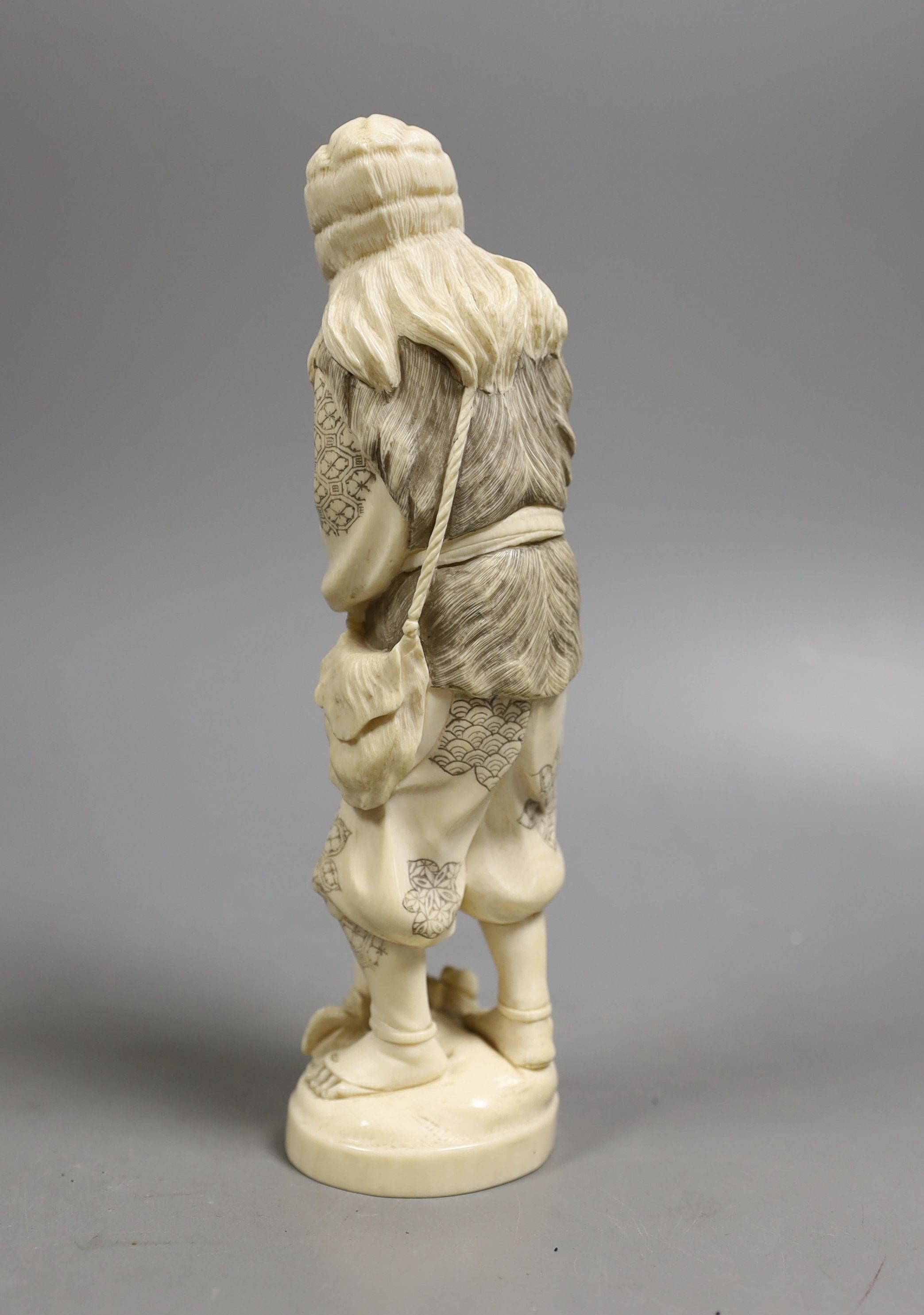 A Japanese ivory figure of a huntsman, early 20th century, 21 cms high.